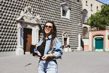 Obraz premium Naples,Italy, Piazza del . Gesu` nuovo.Young beautiful happy smiling woman using a mobile phone taking a pictures.Concept of Italian gastronomy and travel