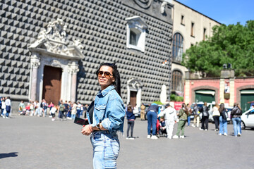 Obraz premium Naples,Italy, Piazza del . Gesu` nuovo.Young beautiful happy smiling woman using a mobile phone taking a pictures.Concept of Italian gastronomy and travel