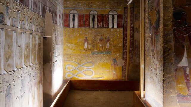 Close-up of ancient Egyptian relief carving inside KV17 tomb of Seti I, Valley of the Kings, Luxor, Egypt, showing a deity figure with black hair and deteriorating pigment.