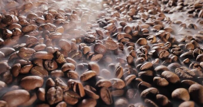 Close up of seeds of coffee. Fragrant coffee beans are roasted smoke comes from coffee beans.