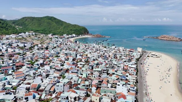 Aerial drone footage of Hon Kho Island in Quy Nhon, Binh Dinh Province, Vietnam. The drone reveals the island's dramatic rocky coastline surrounded by crystal-clear turquoise water, with traditional V