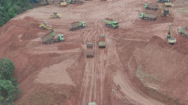 A crawler bulldozer is leveling the fill soil unloaded from a truck for road construction