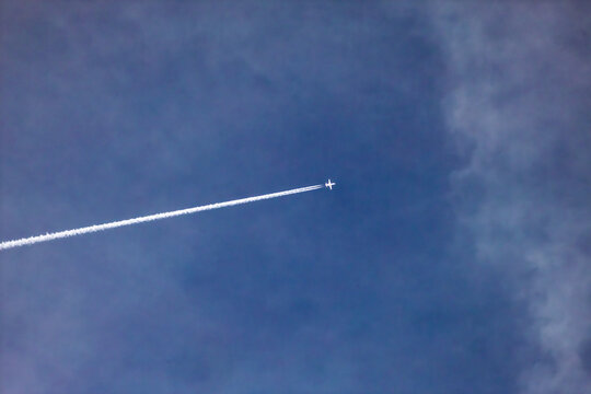 Business Learjet Flying Across Blue Slightly Cloudy Sky in Landscape Orientation with Negative Copy Space Above, Private Jet in Flight from Left to Right, Corporate Aviation Travel Concept