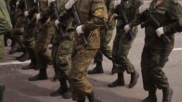 Soldiers wearing uniforms with machine guns in hands march in ranks. Trained servicemen show professional skills in handling firearms during festive National Independence Day. military army parade