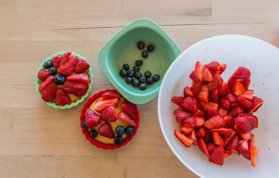 Baking and decorating berry tarts, small berry cakes, directly above