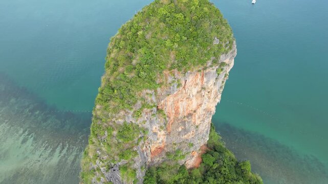Krabi, Thailand : Tilt down aerial drone footage above limestone cliff in Railay, famous place in Andaman coastline in Krabi, Thailand showing forest and underwater reef