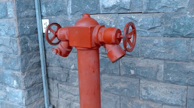 A close-up of a red fire hydrant standing on the sidewalk in Da Lat City, Vietnam