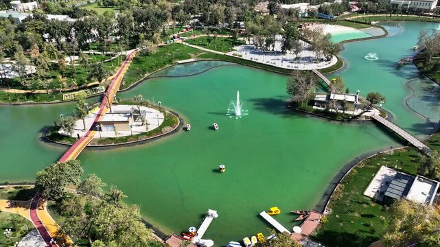 Drone over the city lake with fountains and a castle on the shore. Sunny summer day