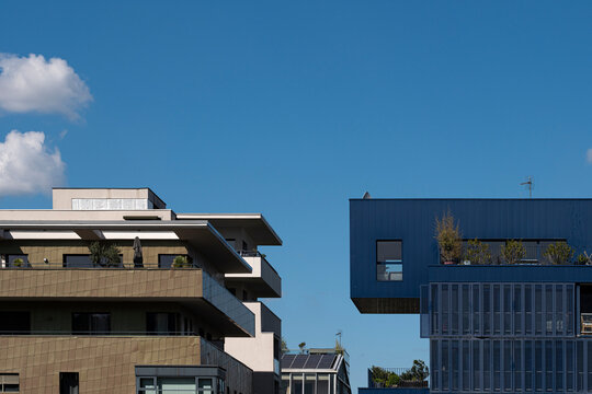 Layered Lyon architecture in La Confluence sits under blue sky and clouds, with residential buildings and facade edges shaping urban space in France
