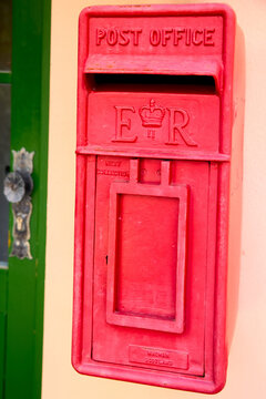 Boxdorf, Bavaria, Germany - May 9, 2026: Vintage red British wall-mounted post office letter box with GR royal cypher, traditional mail delivery service symbol on a building wall.