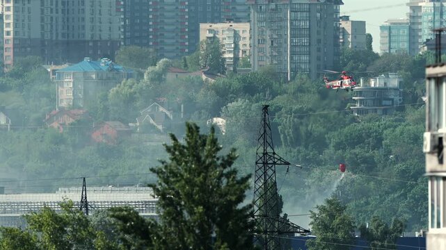 Firefighting helicopter dropping water on a fire after an airstrike in Kyiv, Ukraine.