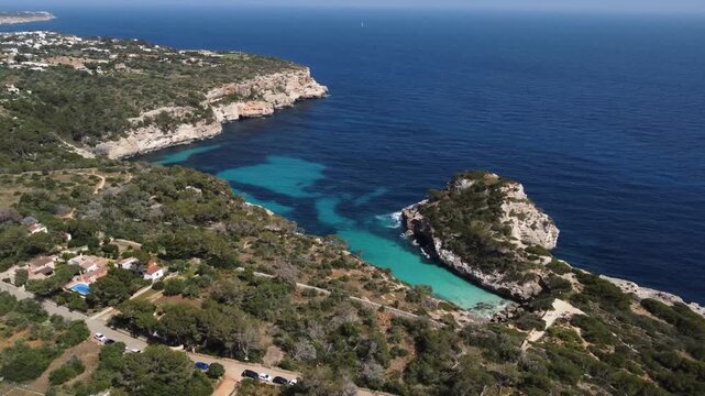 Drone flying towards scenic Cal&oacute; des Moro, secluded beach bay with turquoise waters, Mallorca
