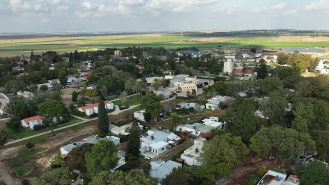 Aerial drone view of the reconstruction efforts in Kibbutz Kfar Aza. The footage shows new construction sites, heavy machinery, and the building of the Young Generation neighborhood as the community p