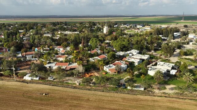 Aerial drone view of the reconstruction efforts in Kibbutz Kfar Aza. The footage shows new construction sites, heavy machinery, and the building of the Young Generation neighborhood as the community p