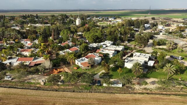 Aerial drone view of the reconstruction efforts in Kibbutz Kfar Aza. The footage shows new construction sites, heavy machinery, and the building of the Young Generation neighborhood as the community p