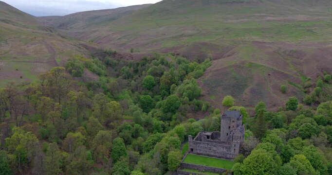 Cinematic flyover of Castle Campbell, a historic castle nestled in the Ochil Hills above the village of Dollar in central Scotland. Shot in spring with bluebells clearly visible behind the castle.