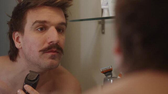 Man trimming beard into Moustache in mirror (4k60p)