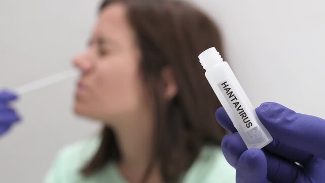 Doctor performing a hantavirus diagnostic test on a female patient using a nasal swab