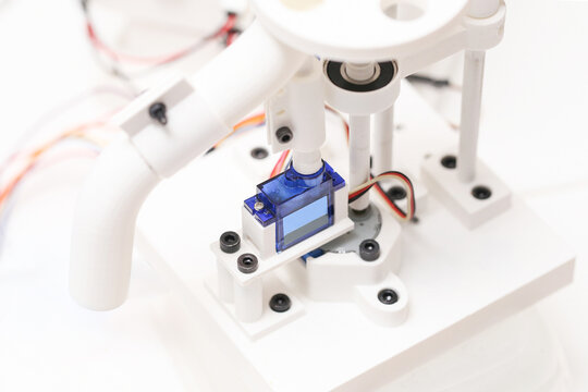 Small robotic arm mechanism close up. Servo motor and electronic components in DIY automation project. Engineering prototype detail. Robotics technology and mechatronics concept