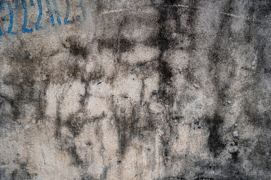 Abstract texture of a weathered wall with dark stains and subtle patterns.