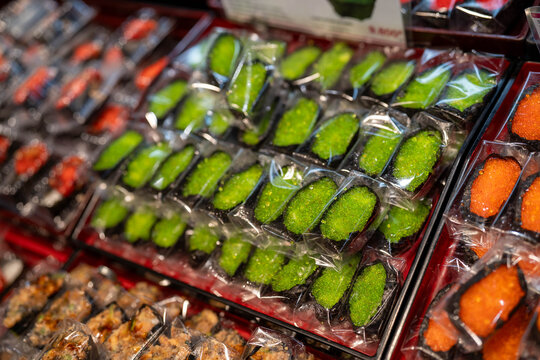 Colorful sushi toppings displayed in a market setting.
