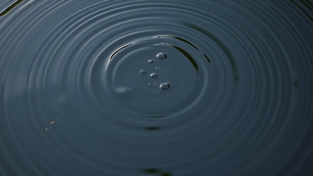 Overhead view of a calm pond with intersecting concentric ripples from multiple impacts.