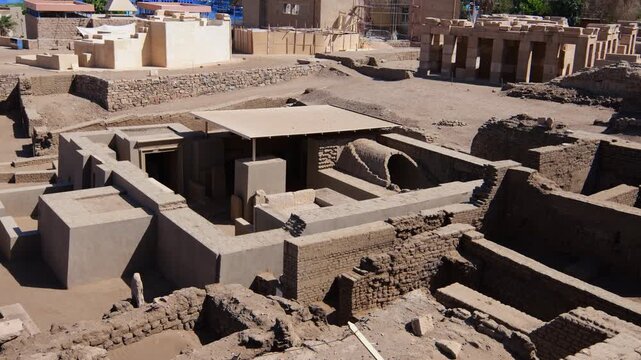 Aerial view of Elephantine Island archaeological excavation site, Aswan, Egypt, with multi-period ruins, restored mud brick structures, temple gateway and active restoration works.