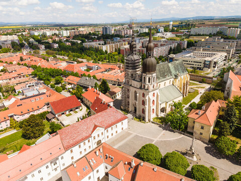 Aerial view of St. Nicholas' Basilica with its iconic twin towers and red rooftops in the historic old town of Trnava, Trnava Region, Slovakia.