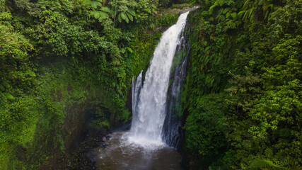 Aerial view of Beautiful Gomblang Waterfall in the middle of forest, Java, Indonesia. Dense waterfall with lush vegetation  © katakaneh