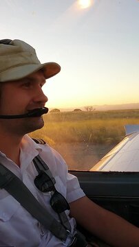 General Aviation Pilot in Cockpit with Flight Instruments Panel and Sunny Sky View. Young Male Pilot in Aviation Headset Controls Light Plane Cockpit During Daytime Flight