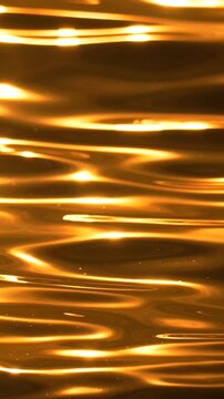 Water reflection abstract, seamless vertical golden sun shimmer on liquid surface creates luxurious texture background
