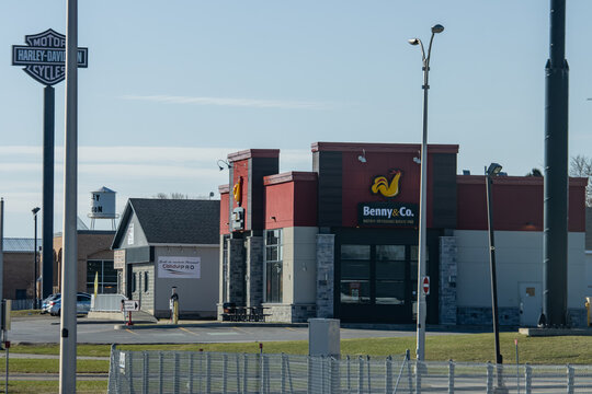Quebec, Canada, 24 April 2026 : Benny & Co. restaurant building stands near a Harley-Davidson sign and ConduiPRO driving school.