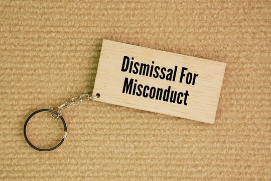 Wooden tag with the words Dismissal for misconduct. the termination of an employee for violating company policies or employment terms