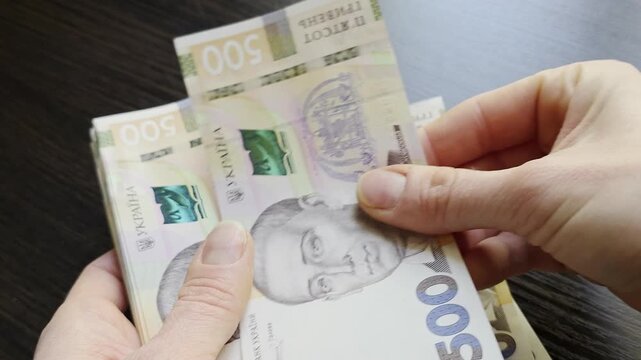 Woman hands counting stack of Ukrainian hryvnia cash banknotes