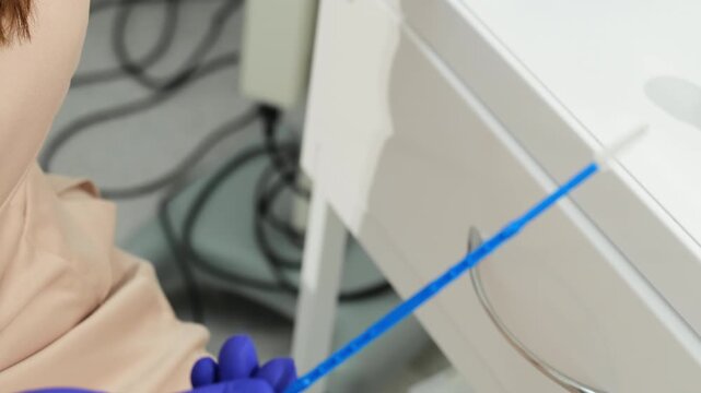 Gynecologist opens sterile package preparing swab for Pap test. Specialist removes collection tool carefully starting sample routine