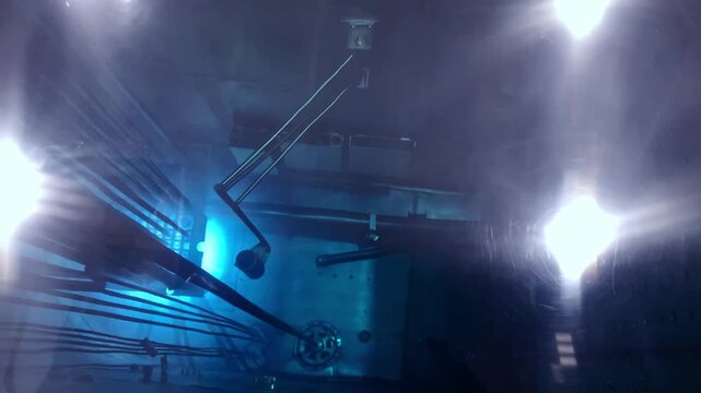 Blue glow water of nuclear reactor core powered, caused by Cherenkov radiation, fuel plates industrial uran.