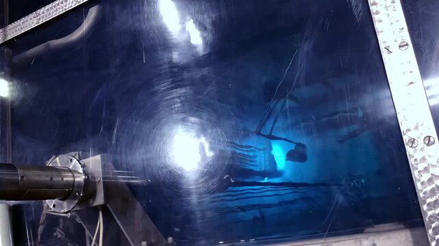 Blue glow water of nuclear reactor core powered, caused by Cherenkov radiation, fuel plates industrial uran.