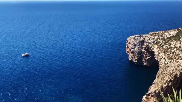 Blue Grotto in Malta. Pleasure boat with tourists runs. Natural arch window in rock.