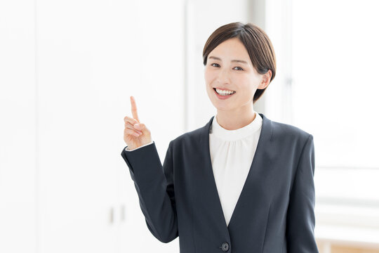 人差し指を立ててポイントを説明する笑顔のビジネスパーソン
