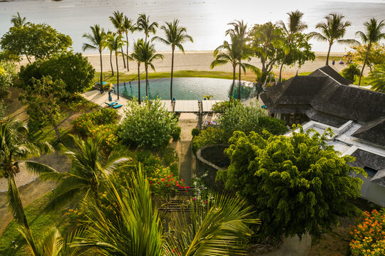 Aerial view of a luxury tropical resort with a swimming pool and palm trees along the coast in Mauritius, Moka District, Mauritius.