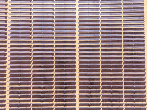 Aerial view of rows of solar panels in a large photovoltaic power station in the desert Lucerne Valley, California, United States.