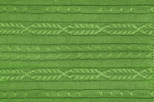 Vibrant green knitted wool texture with trendy cable stitch pattern