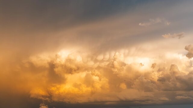 Sunset clouds glowing brightly through a dark and moody evening sky