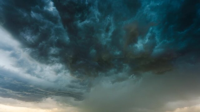 Dark rain clouds rolling and forming in turbulent stormy sky background