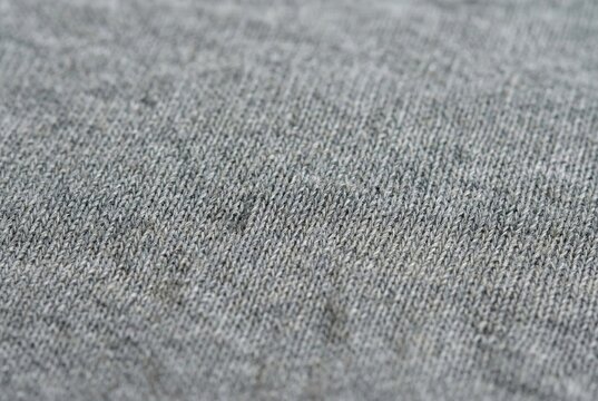 Close up of a small snag or loose thread defect in grey knitted clothing