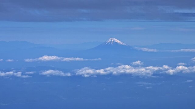 飛行機の機内から望む雲海と雪化粧をした富士山（スローモーション）