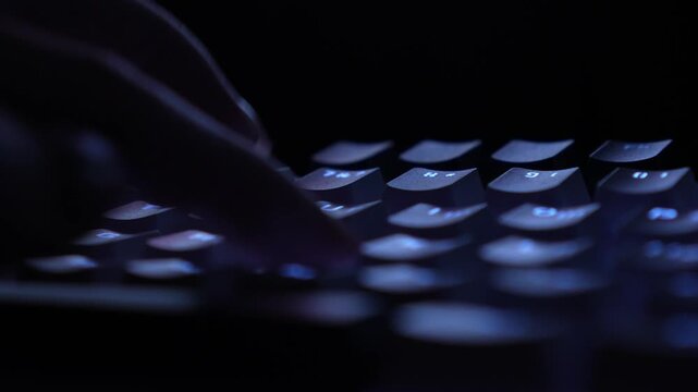 woman typing on keyboard, close-up. white custom keyboard with English and Ukrainian layout with pulsating backlight. dark night shot without light