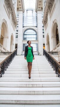 Elegant African American businesswoman descending a grand marble staircase, symbolizing leadership and career success. Ideal for corporate, empowerment, and professional lifestyle content.