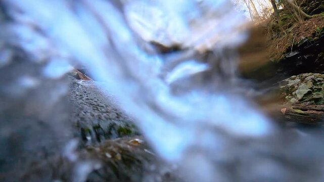 Close up split shot of rushing water in mountain stream. Shutter motion blur of clean water splashing over mossy rocks in a creek at Mount Tammany.