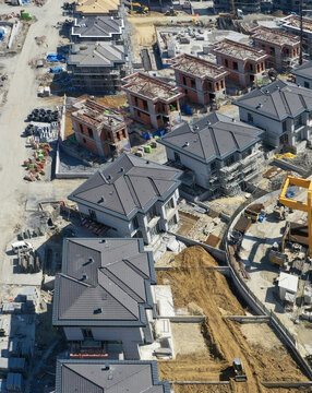 Aerial view of a modern residential construction site with villas featuring grey rooftops and brick walls under development in Avcilar, Istanbul, Turkiye.